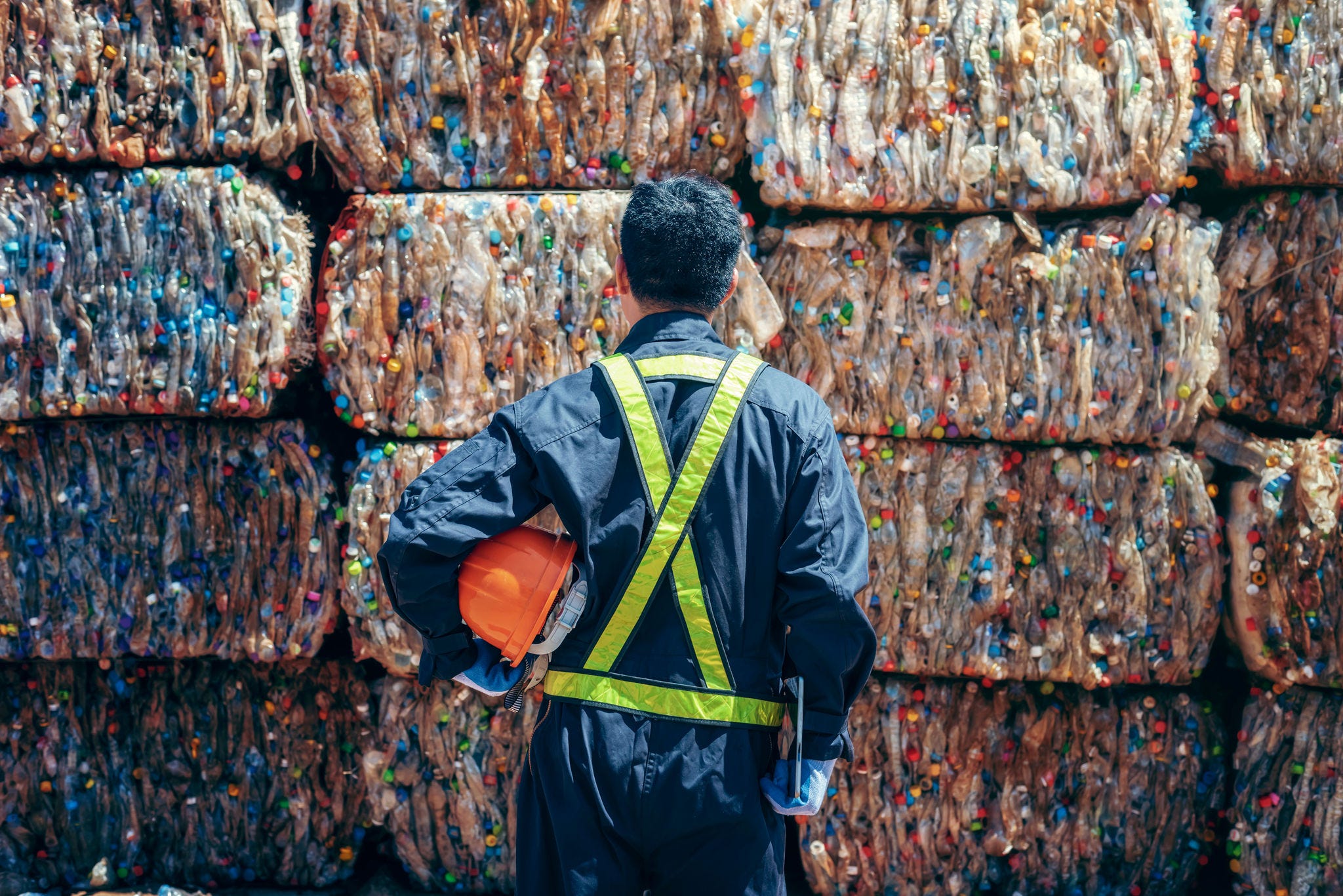 Engineer Standing and looking at stacked recycled materials