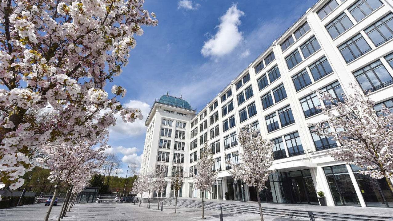 OECD Boulogne building facade with cherry trees in bloom.