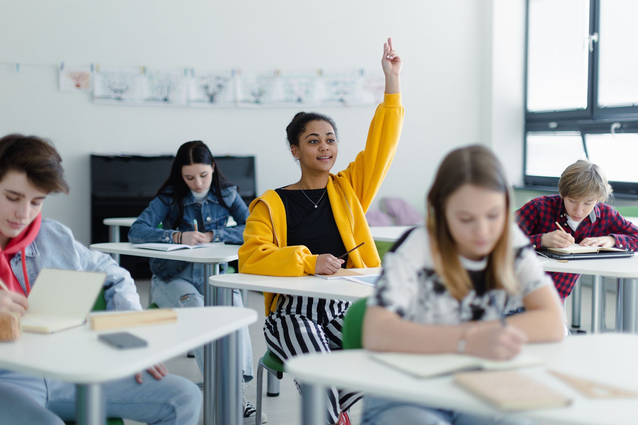 High school students paying attention in class, sitting in their desks and raising hand.; Shutterstock ID 2190204257; NP: New website