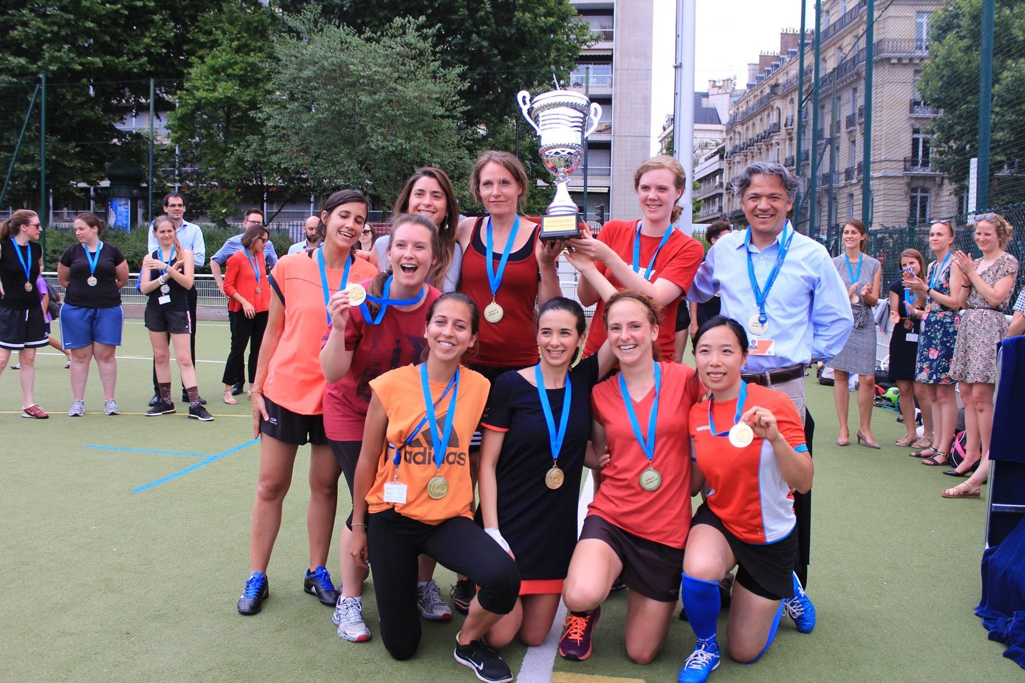 A group of OECD employees holding medals and a trophy after having won a competition organised by one of the Organisation's staff associations