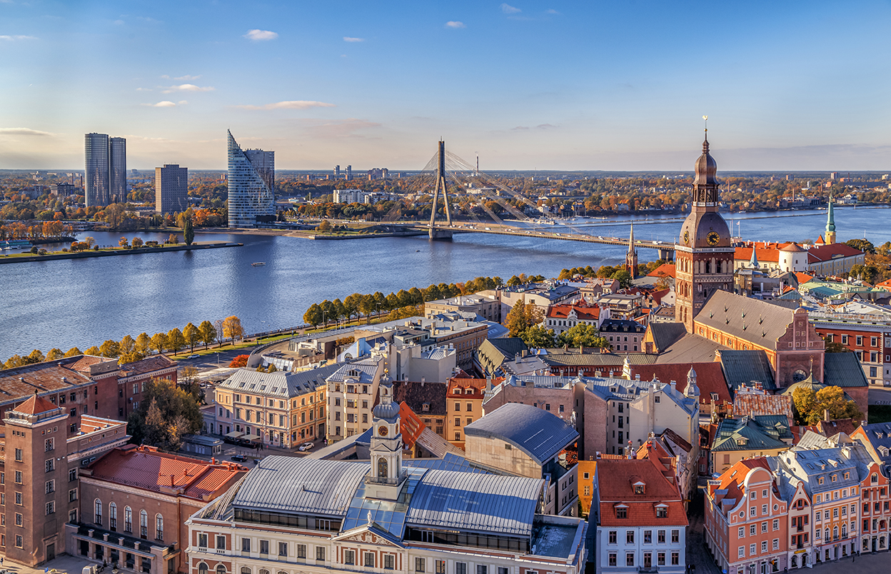 Riga, Latvia. Aerial panoramic view from the tower of St. Peter's Church to the city, Daugava river, historical centre with old buildings and colourful roofs in the foreground. Travel Europe. ; Shutterstock ID 1681324117; NP: Latvia Economic Survey